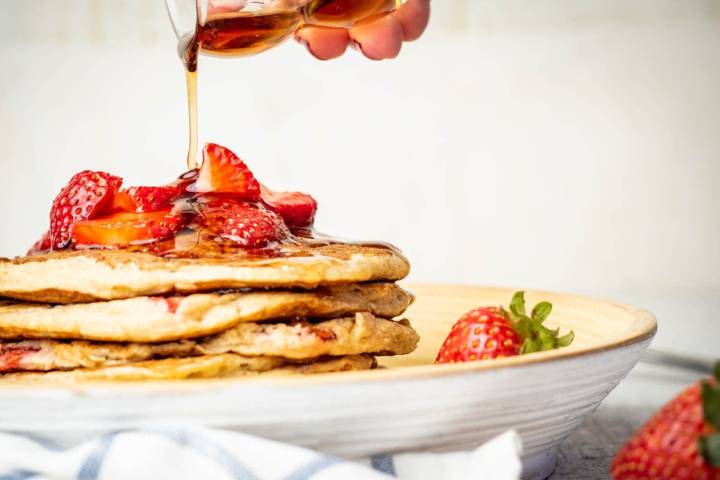 32 Weight Watchers Breakfasts Under 5 Points Strawberry Banana Oat Pancakes with maple syrup being poured on top.