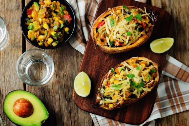 Southwest Stuffed Sweet Potato Stuffed sweet potatoes with Southwest ingredients including black beans, corn, diced tomatoes, green peppers, and cheese.