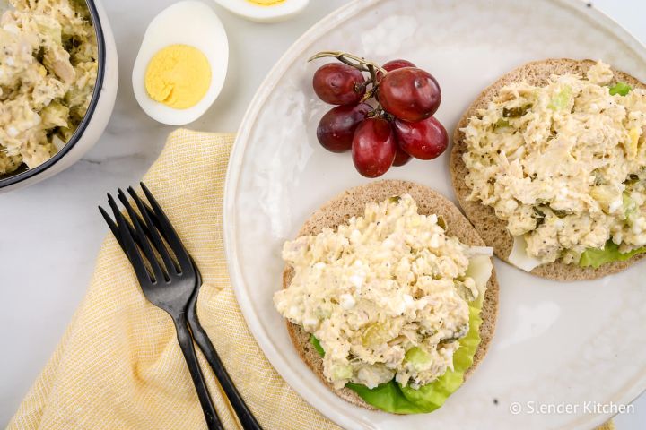 Tuna Egg Salad Tuna egg salad on a sandwich thin with red grapes and lettuce.