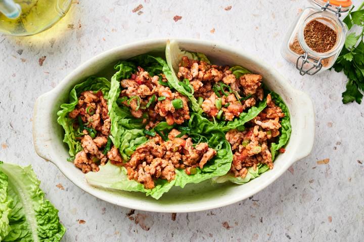 Turkey Taco Lettuce Wraps Turkey taco lettuce wraps with tomatoes, shredded cheese, ground turkey, and avocado.