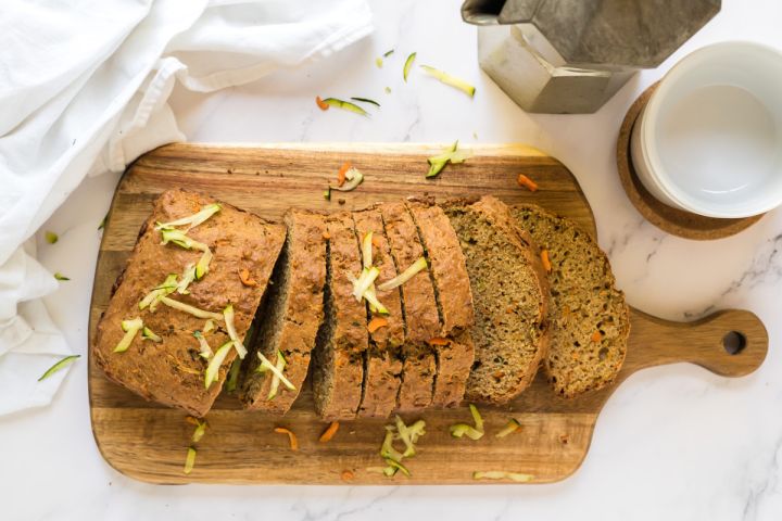 Zucchini Carrot Bread Zucchini carrot bread made with shredded zucchini, carrots, and whole wheat flour sliced on a wooden cutting board.