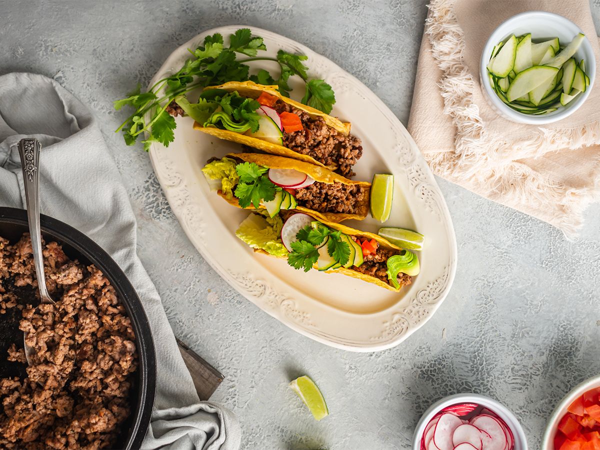 Quick and Easy Beef Dinner Recipes Ground beef tacos with ancho chili seasoning served in baked taco shells with lettuce, tomato, and cilantro.