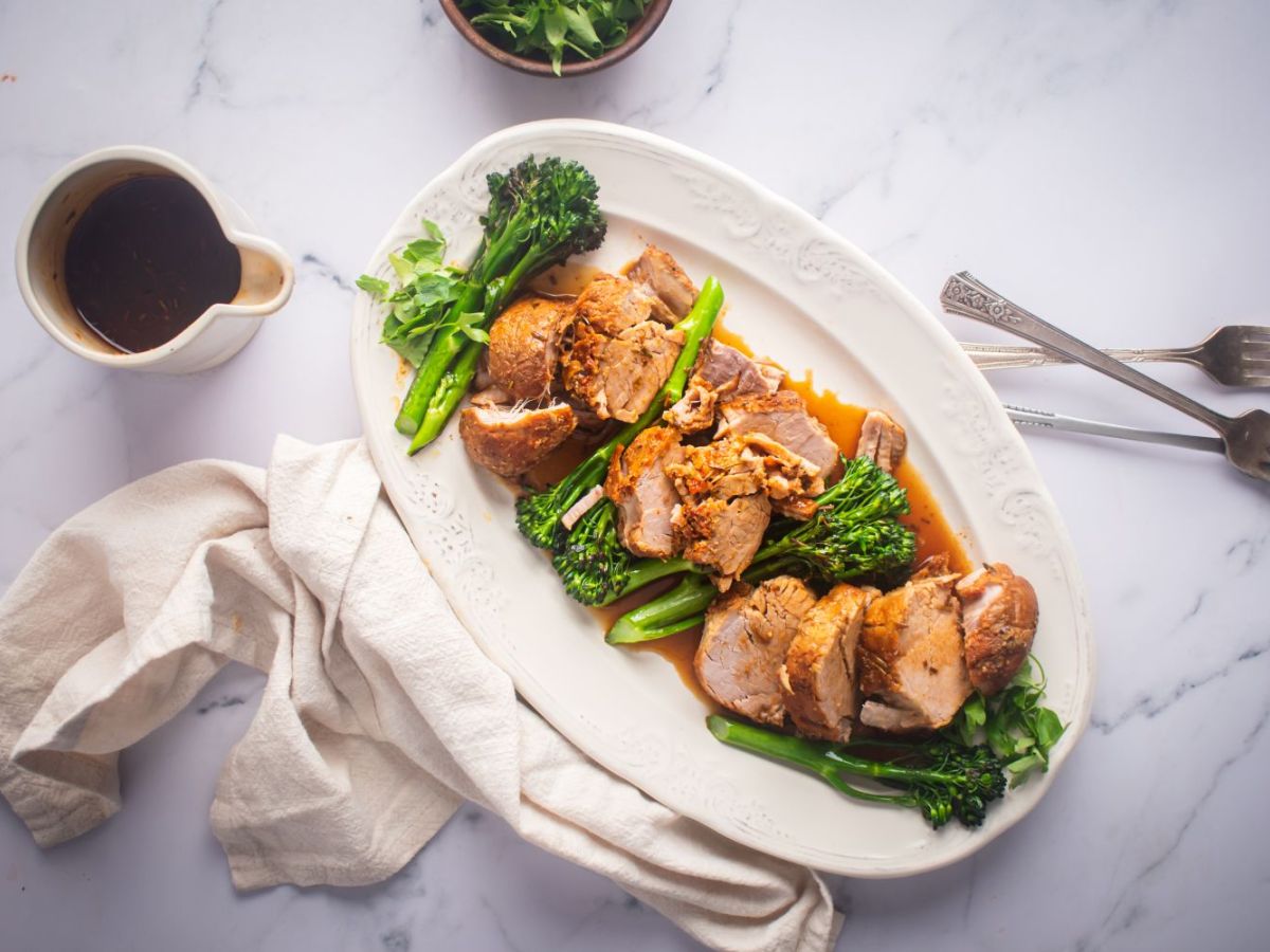 Healthy Slow Cooker Recipes Slow cooker pork tenderloin with mustard sauce and broccolini on a white platter.