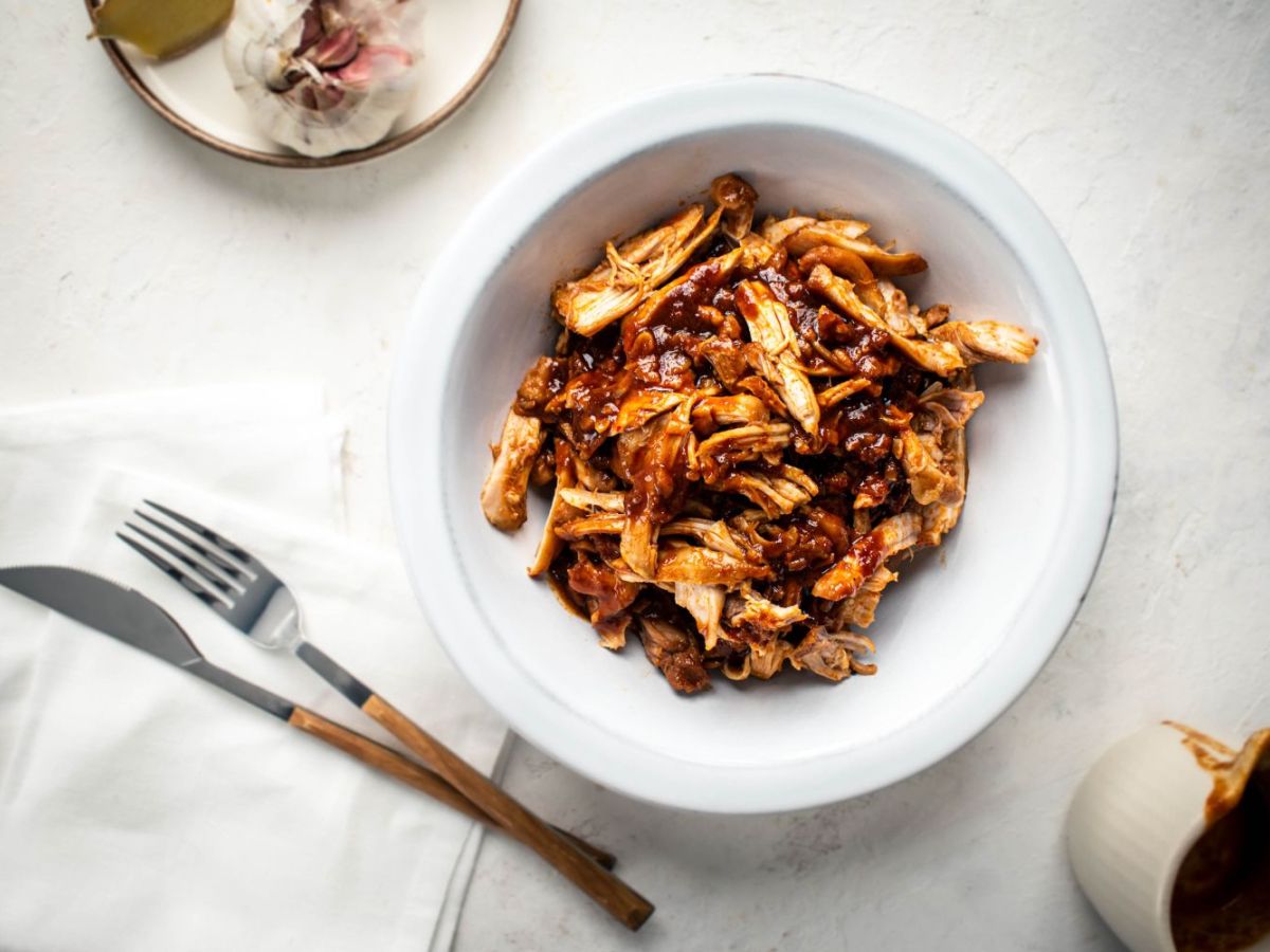 Slow Cooker Chicken Recipes Slow cooker sweet and spicy chicken with soy sauce, Asian chili paste, and ginger in a bowl.