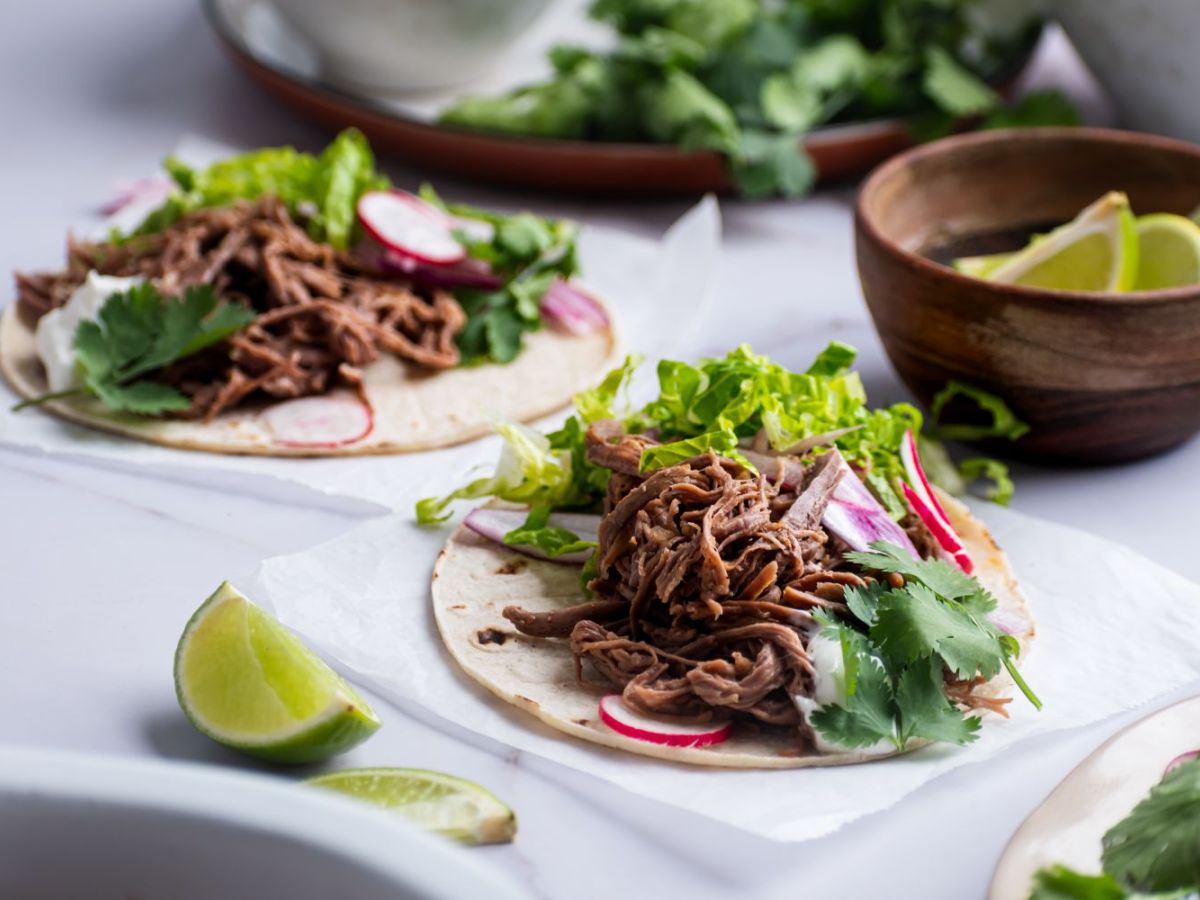 Slow Cooker Beef Recipes Slow cooker tri tip tacos on white corn tortillas with lettuce, cilantro, and radishes.