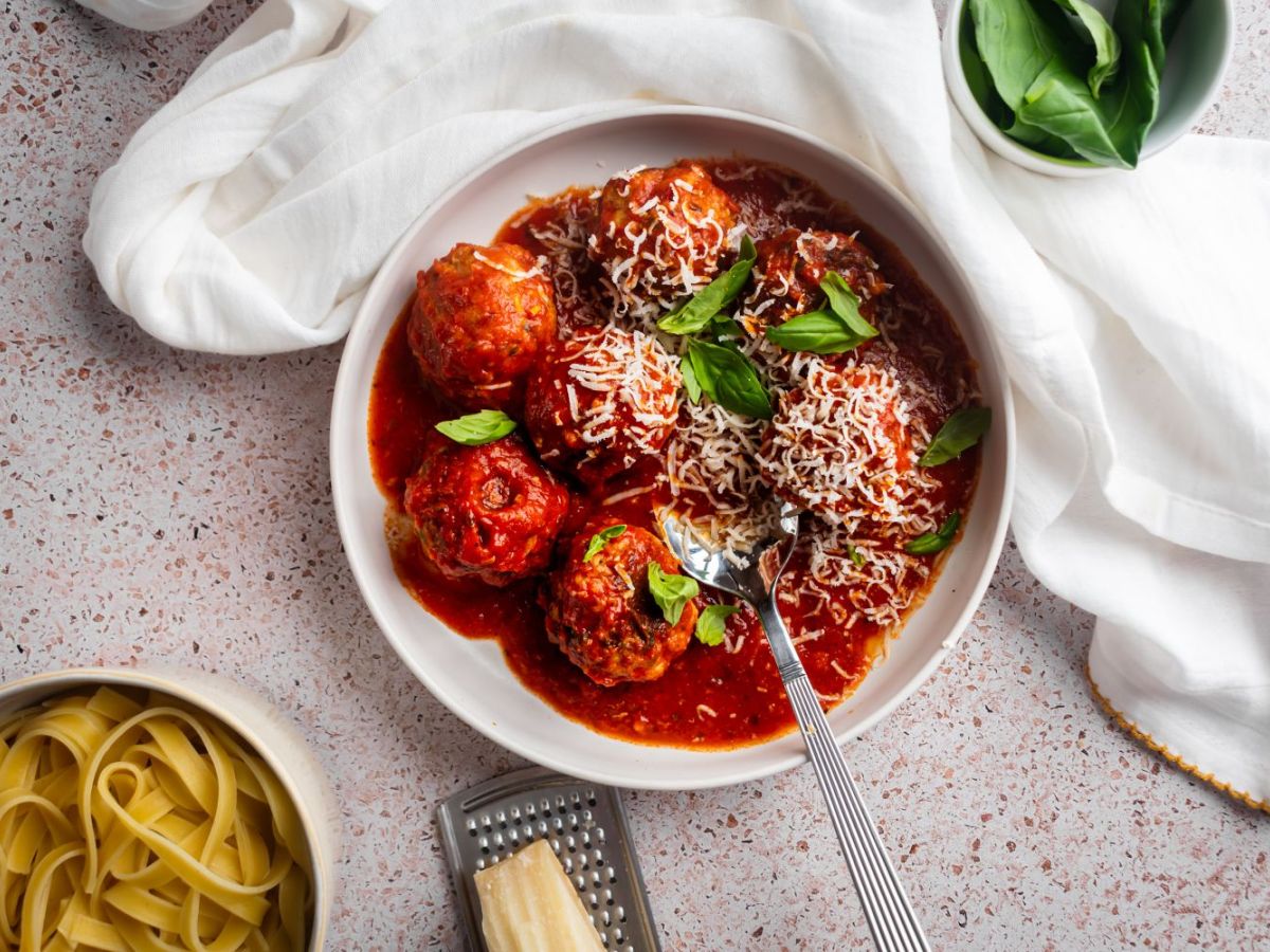 Slow Cooker Turkey Recipes Slow cooker turkey meatballs in a shallow bowl with marinara sauce, fresh basil, and Parmesan cheese.