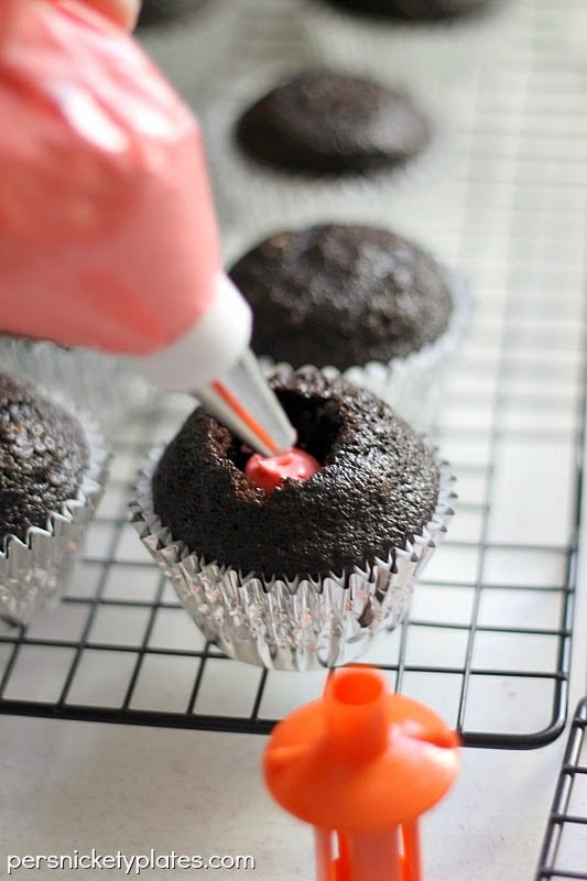 Dark chocolate gender reveal cupcakes filled with pink (or blue) frosting. A fun way to reveal baby's gender! | www.persnicketyplates.com