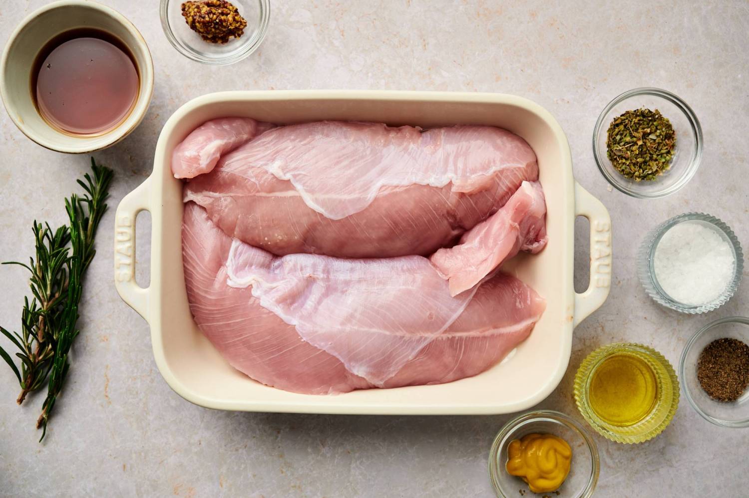 Ingredients for grilled turkey breast including turkey breast tenderloins, maple syrup, mustard, rosemary, salt, allspice, and olive oil.