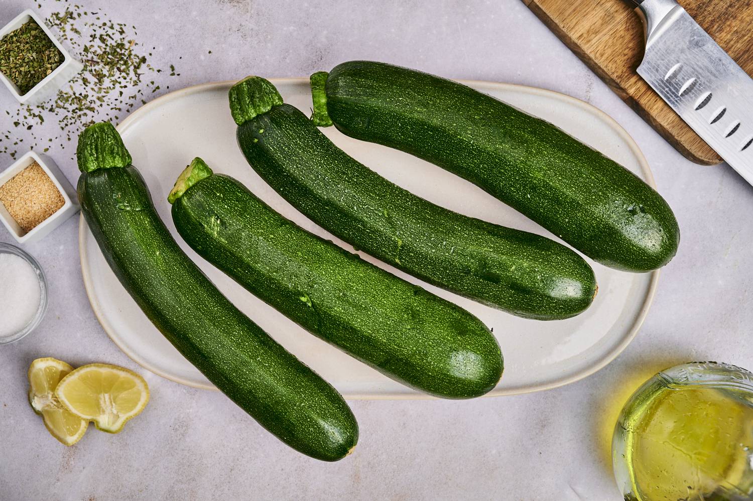 Ingredients for grilled zucchini including zucchini, olive oil, salt, pepper, Italian seasoning, and garlic powder.