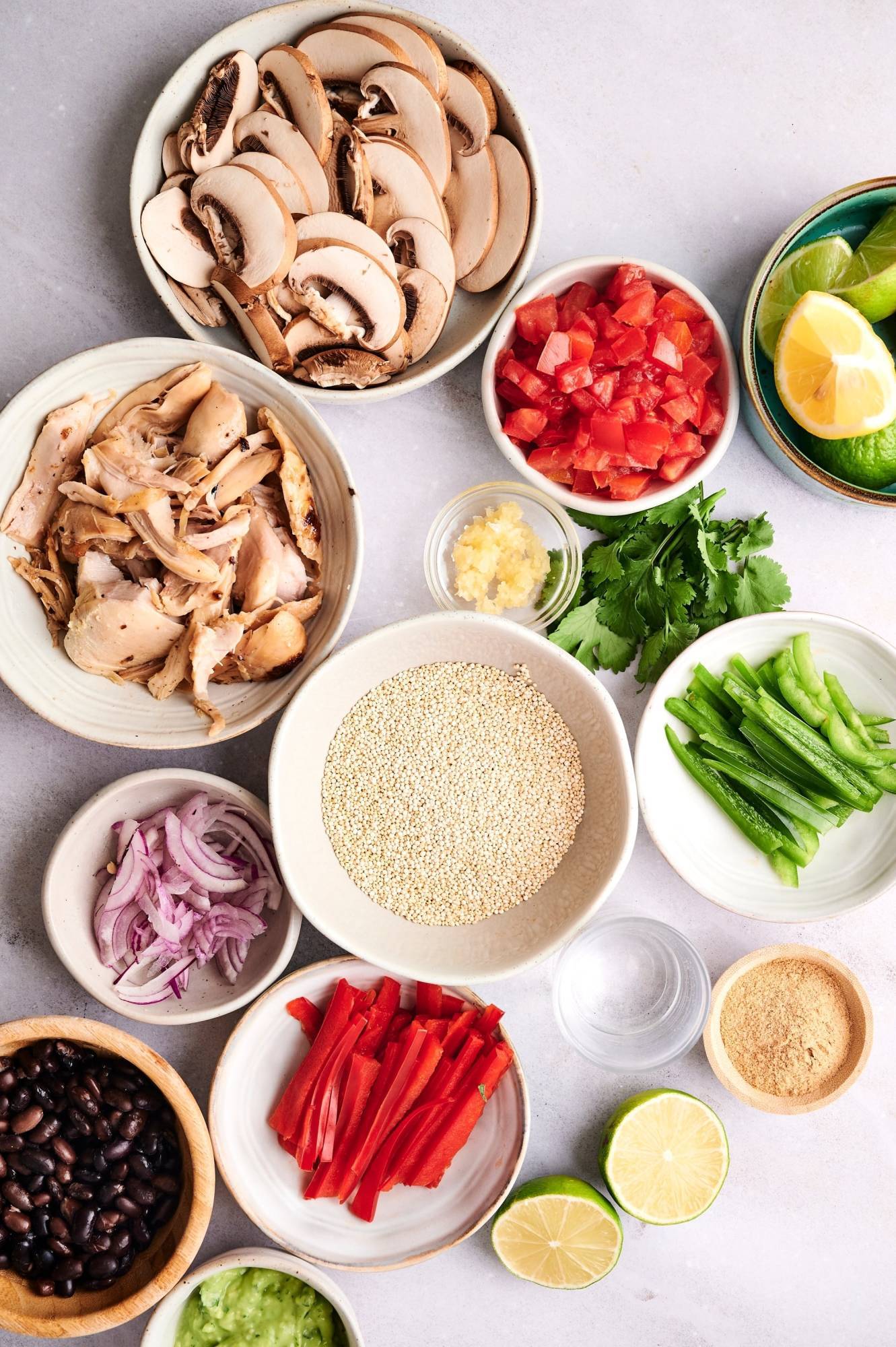 Ingredients for rotisserie chicken taco bowls included shredded chicken, quinoa, bell peppers, onions, beans, and spices.