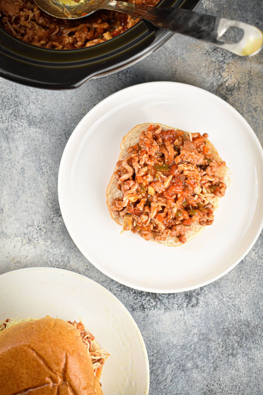 Turkey sloppy joes in an Italian tomato sauce in a crockpot and scooped on a roll.