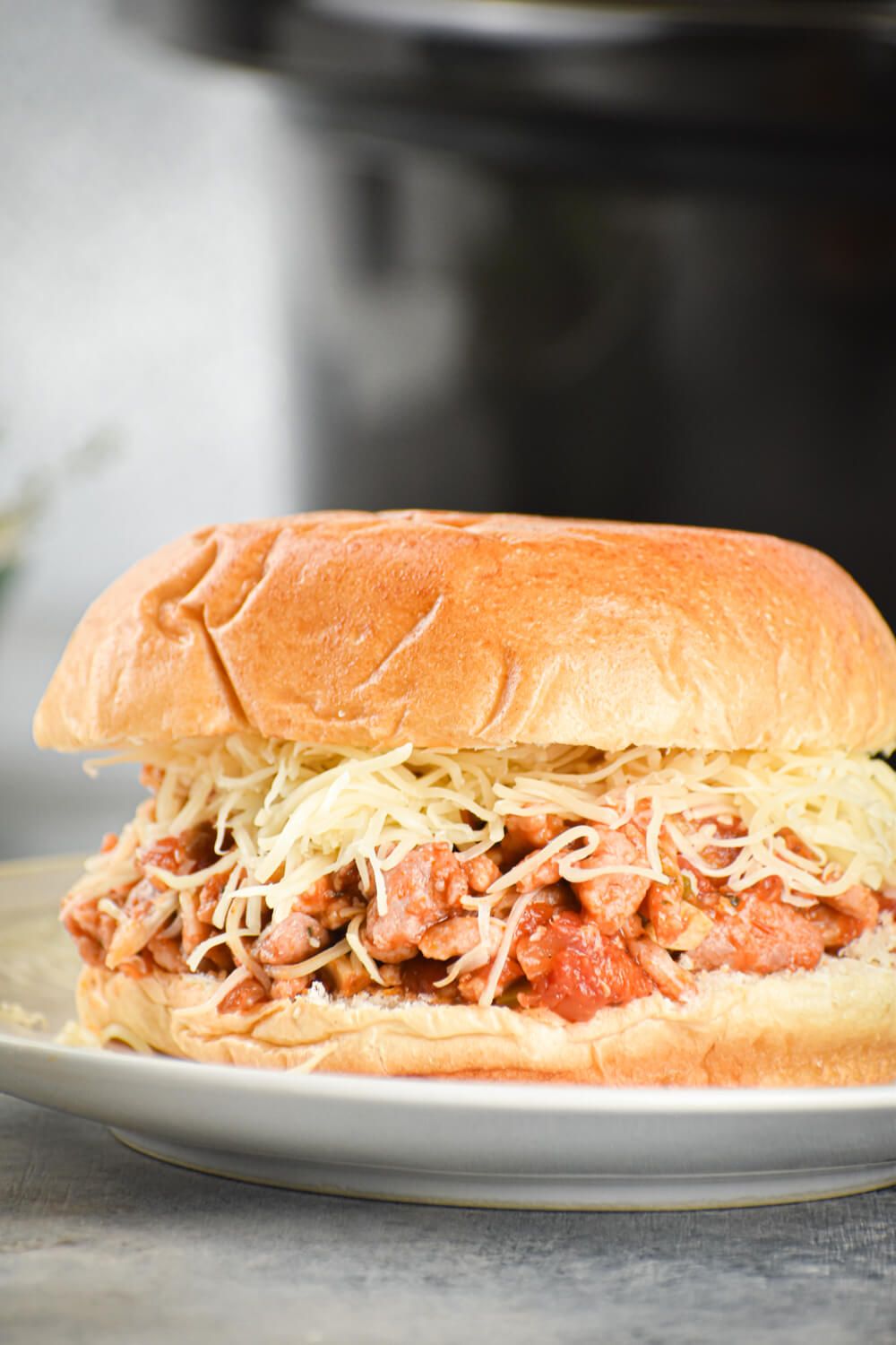 Crockpot sloppy joes made with turkey, peppers, mushrooms, and tomato sauce on a bun with cheese.