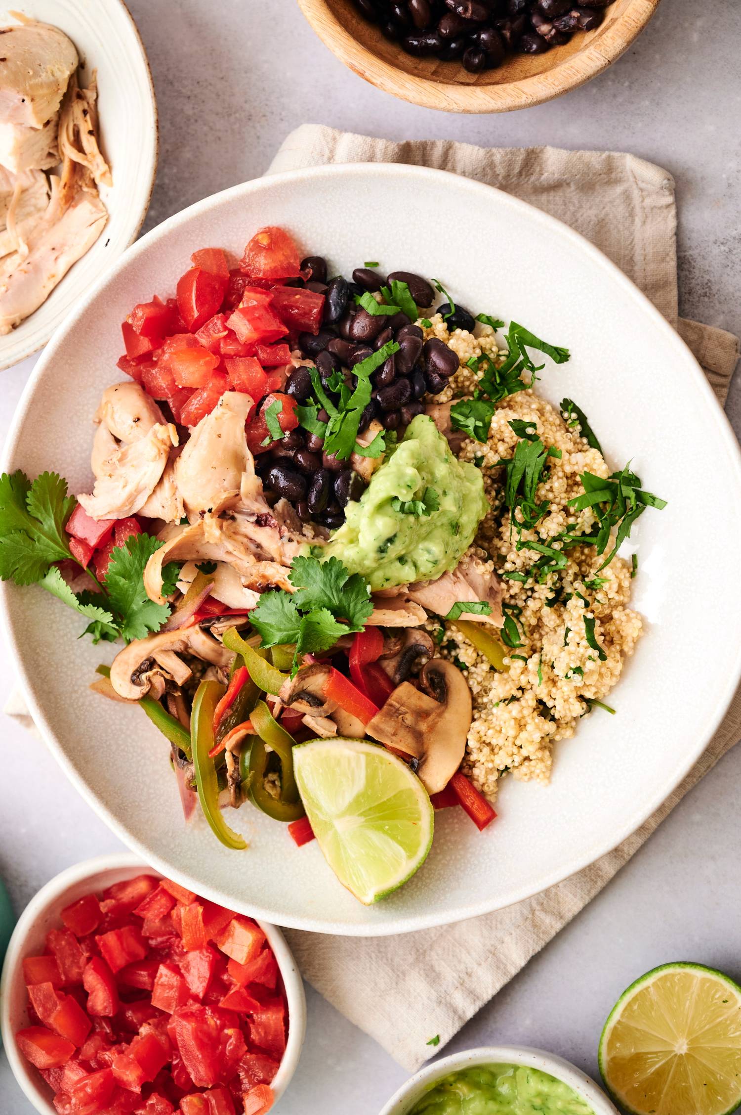 Taco bowls with rotisserie chicken, black beans, quinoa, tomatoes, peppers, onions, and cilantro.