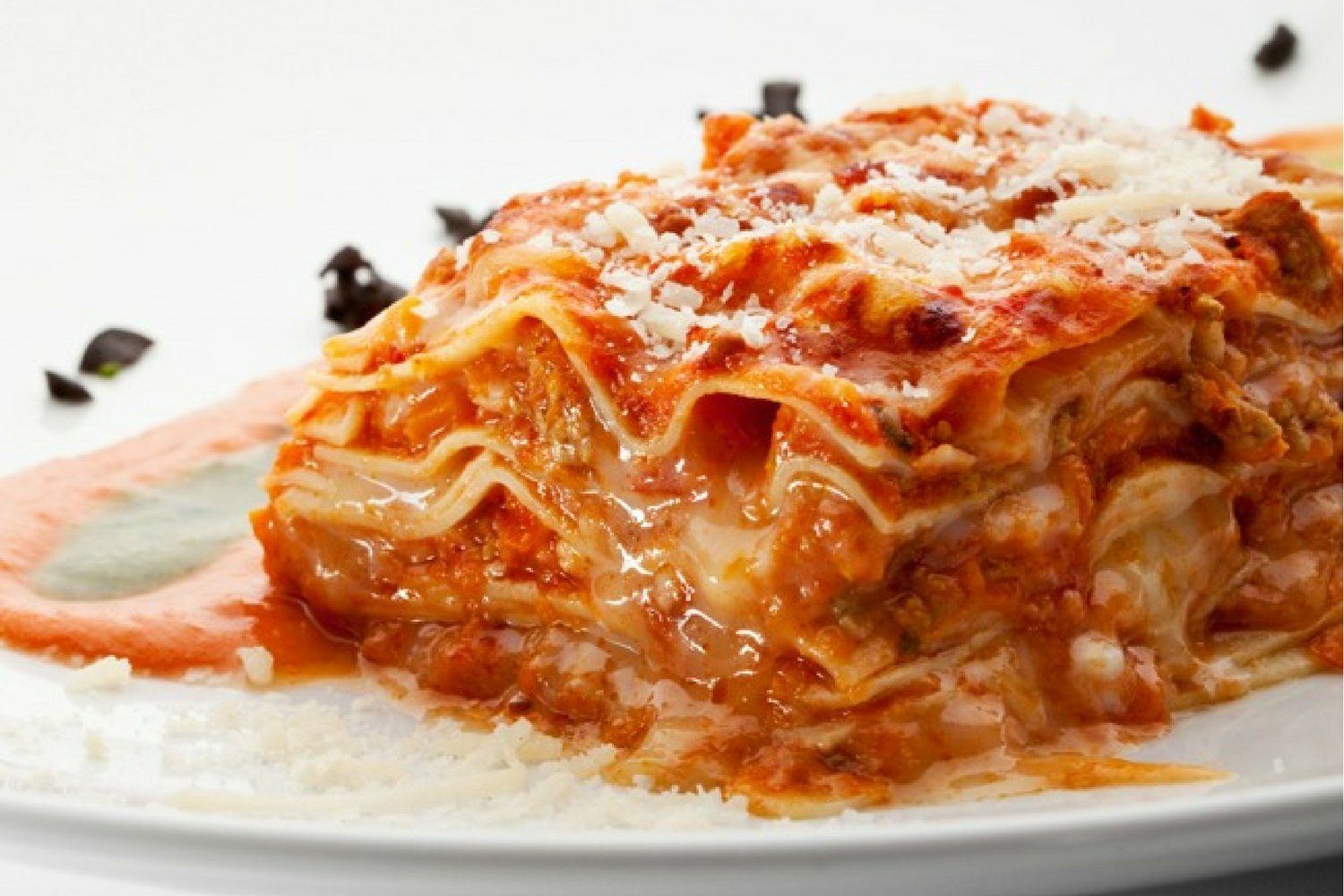 Chicken Parmesan lasagna with ricotta cheese and cooked chicken on a plate.