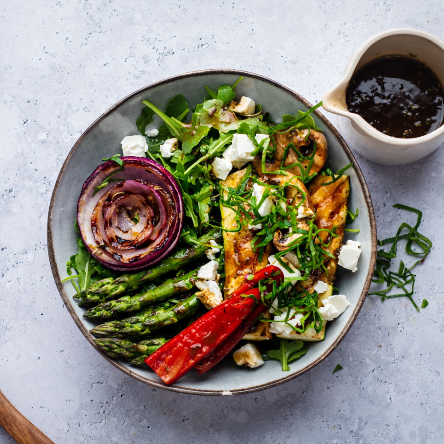 Grilled vegetabe salad with zucchini, asparagus, mushrooms, peppers, onions, and feta cheese served over arugula.