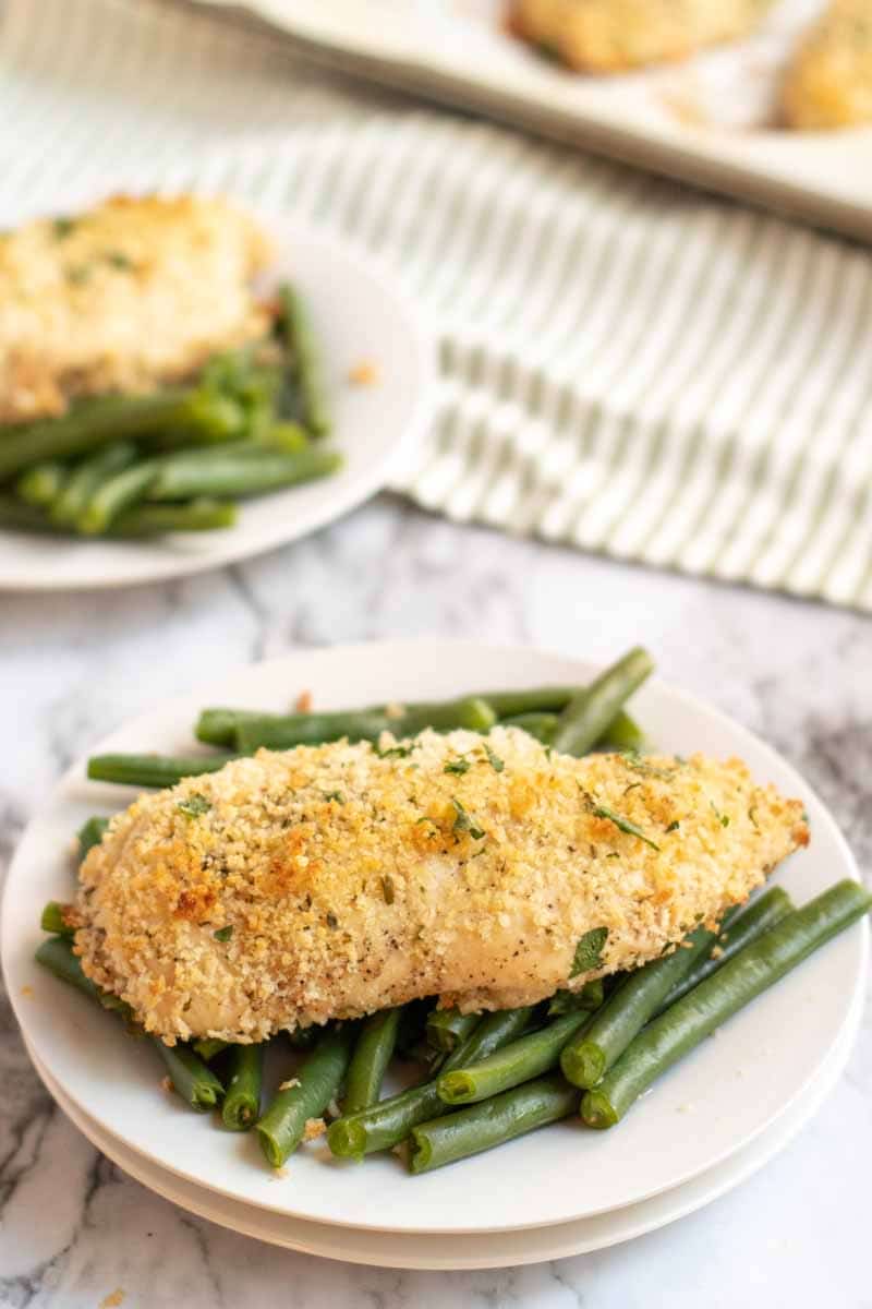 A baked breast of Laughing Cow Chicken sitting on top of green beans on a white plate Laughing Cow Chicken is a lightened up version of a stuffed chicken breast. This super easy, 5 ingredient dinner will please your picky eaters and wow your foodies. | www.persnicketyplates.com