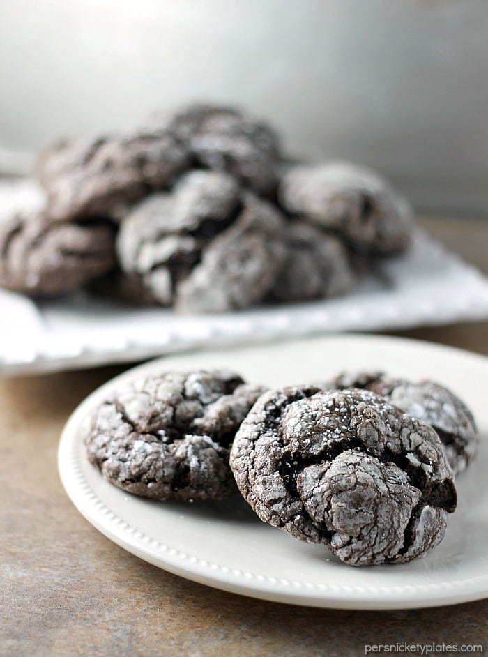 Chocolate Gooey Butter Cookies are light and pillowy and melt in your mouth! At only six ingredients, they just might be your new favorite cookie! | www.persnicketyplates.com #dessert #cookies #cakemixcookies #chocolate #baking #easyrecipe #semihomemade #christmascookies chocolate gooey butter cookies sprinkled with powdered sugar