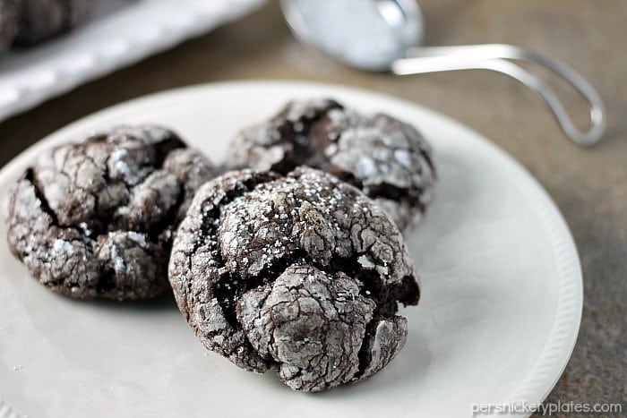 Chocolate Gooey Butter Cookies are light and pillowy and melt in your mouth! At only six ingredients, they just might be your new favorite cookie! | www.persnicketyplates.com #dessert #cookies #cakemixcookies #chocolate #baking #easyrecipe #semihomemade #christmascookies three gooey butter cookies on a white plate