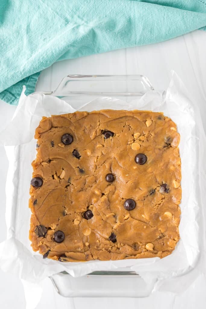 unbaked blondie dough pressed into a baking dish.