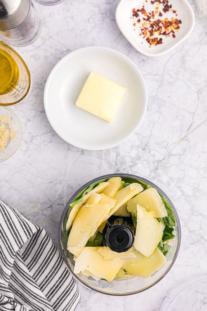 overhead shot of pesto being made in a mini food processor.