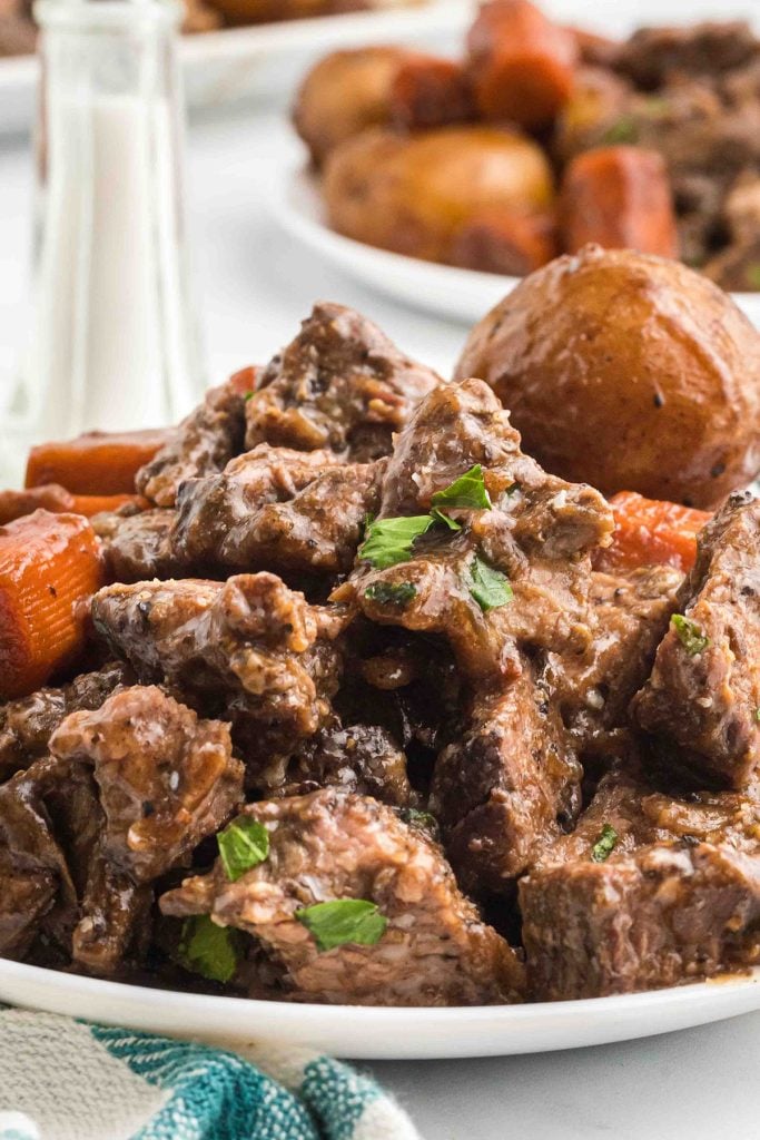 plate full of roast beef, potatoes, and carrots.