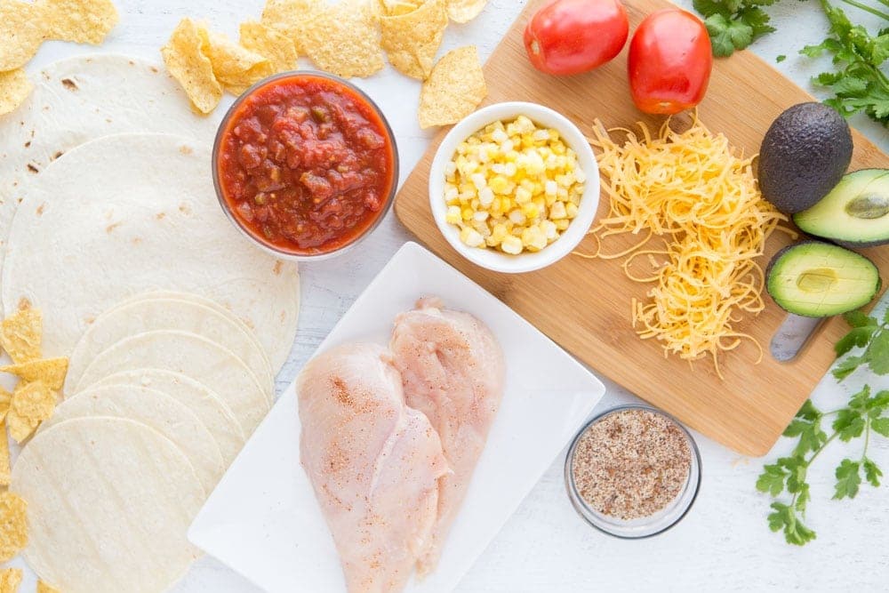 ingredients prepped for crockpot salsa chicken Three ingredient Crock Pot Salsa Chicken is in my regular dinner rotation because it's so easy & so good! Flavorful and versatile, this crockpot chicken breast recipe can be made into burritos, taco bowls, nachos, whatever you feel like!