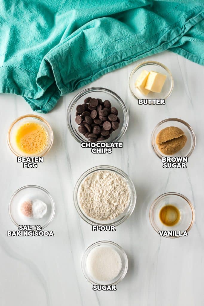 overhead shot of labeled ingredients laid out to make a chocolate chip cookie.