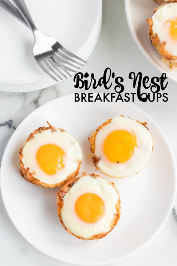 Bird's Nest Breakfast Cups are a fun way to eat eggs and hash browns for breakfast. These baked egg cups combine hash browns and cheese to form a "nest" and are topped with an egg. | www.persnicketyplates.com overhead shot of bird's nest breakfast cups on white plate with forks