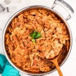 overhead shot of bow tie pasta lasagna skillet with a spoon.