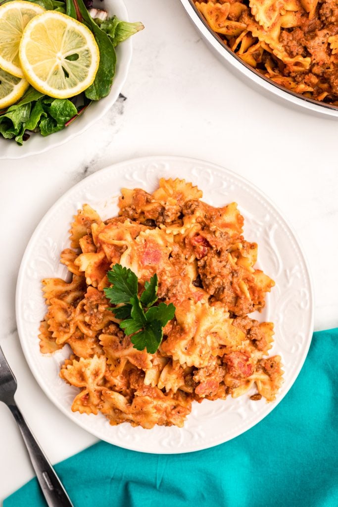 plate of bow tie pasta garnished with parsley.