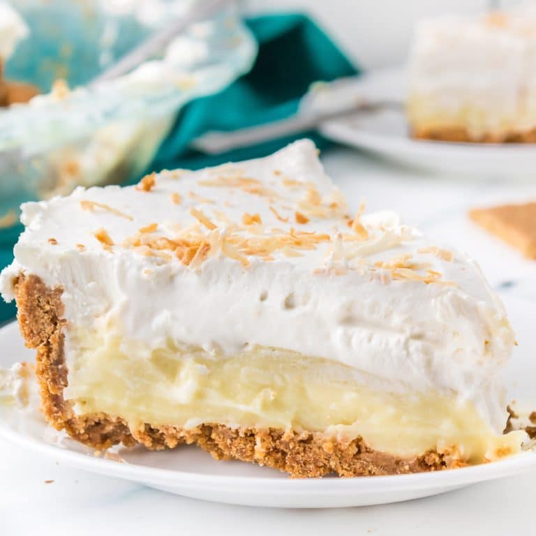 slice of coconut cream pie on a white plate.