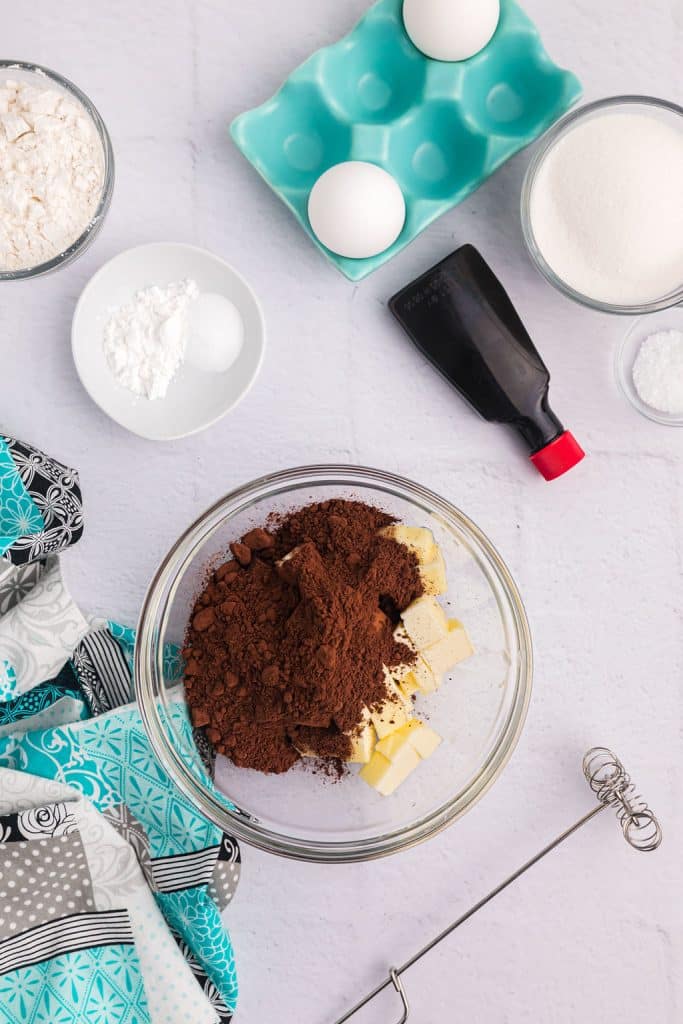 overhead shot of cocoa powder & butter in a mixing bowl.