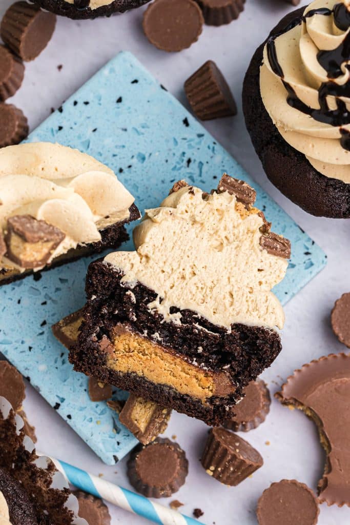 overhead shot of a chocolate cupcake cut in half filled with a reese's cup.