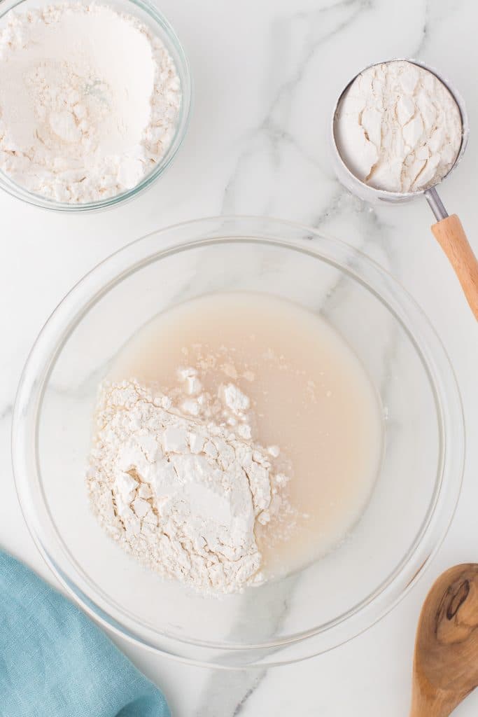 flour in a mixing bowl with yeast mixture.