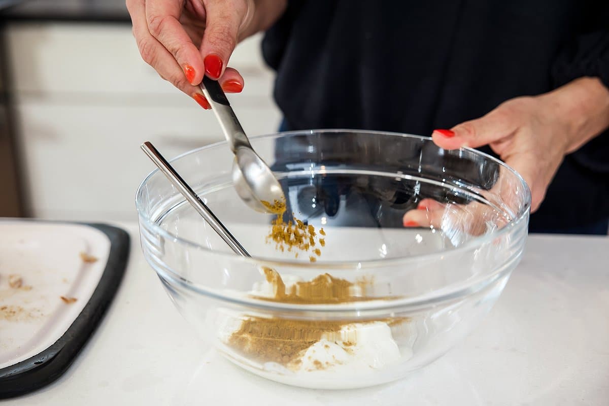 adding curry powder to a bowl