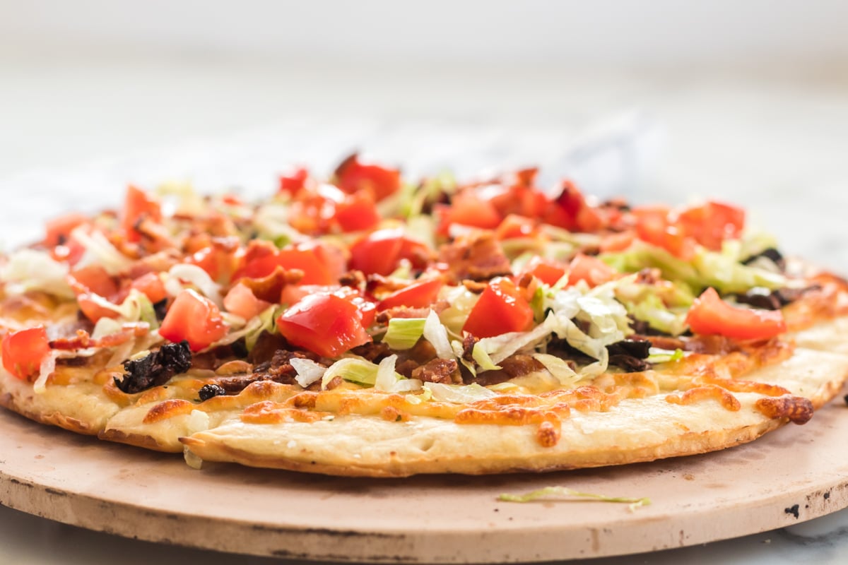 side view of blt pizza on pizza stone