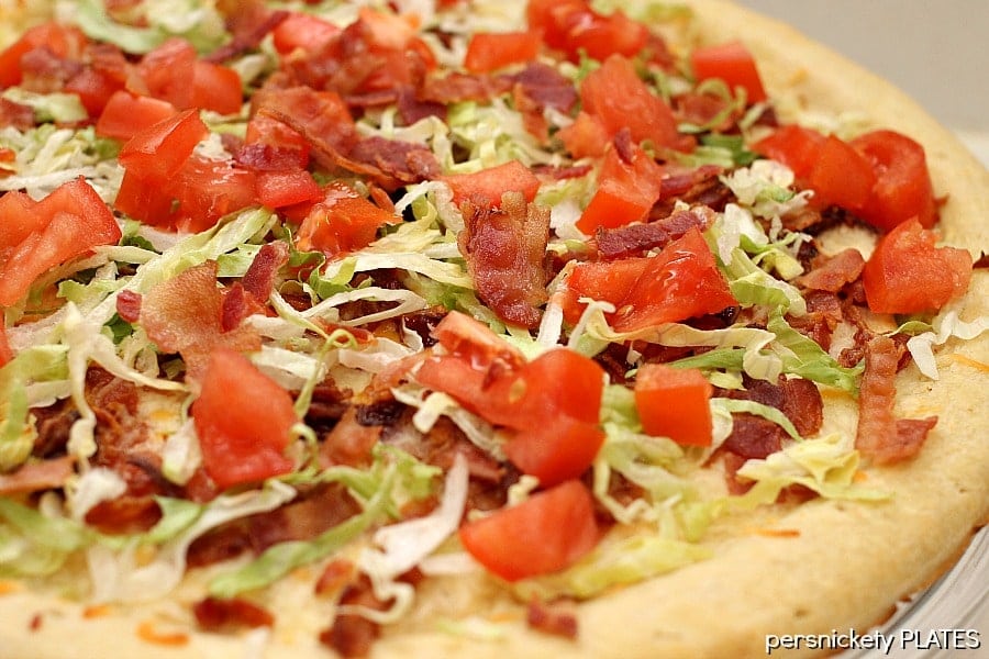 close up of blt pizza with fresh lettuce & tomatoes on top