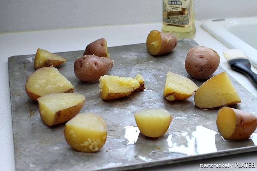Crash Hot Potatoes are like a mix of a fluffy baked potato and a crispy french fry. The perfect side dish for your next dinner! | www.persnicketyplates.com #potatoes #sidedish #vegetarian #easyrecipe red skin potatoes on a baking sheet
