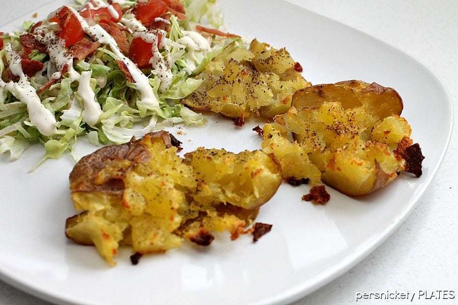 Crash Hot Potatoes are like a mix of a fluffy baked potato and a crispy french fry. The perfect side dish for your next dinner! | www.persnicketyplates.com #potatoes #sidedish #vegetarian #easyrecipe crash hot potatoes on a white plate with a side salad