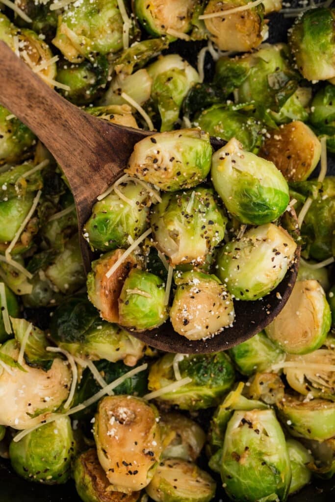 wooden spoon scooping garlic parmesan brussels sprouts.