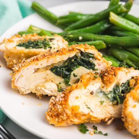 Cajun stuffed chicken breasts sliced open with gooey melted cheese and spinach inside.