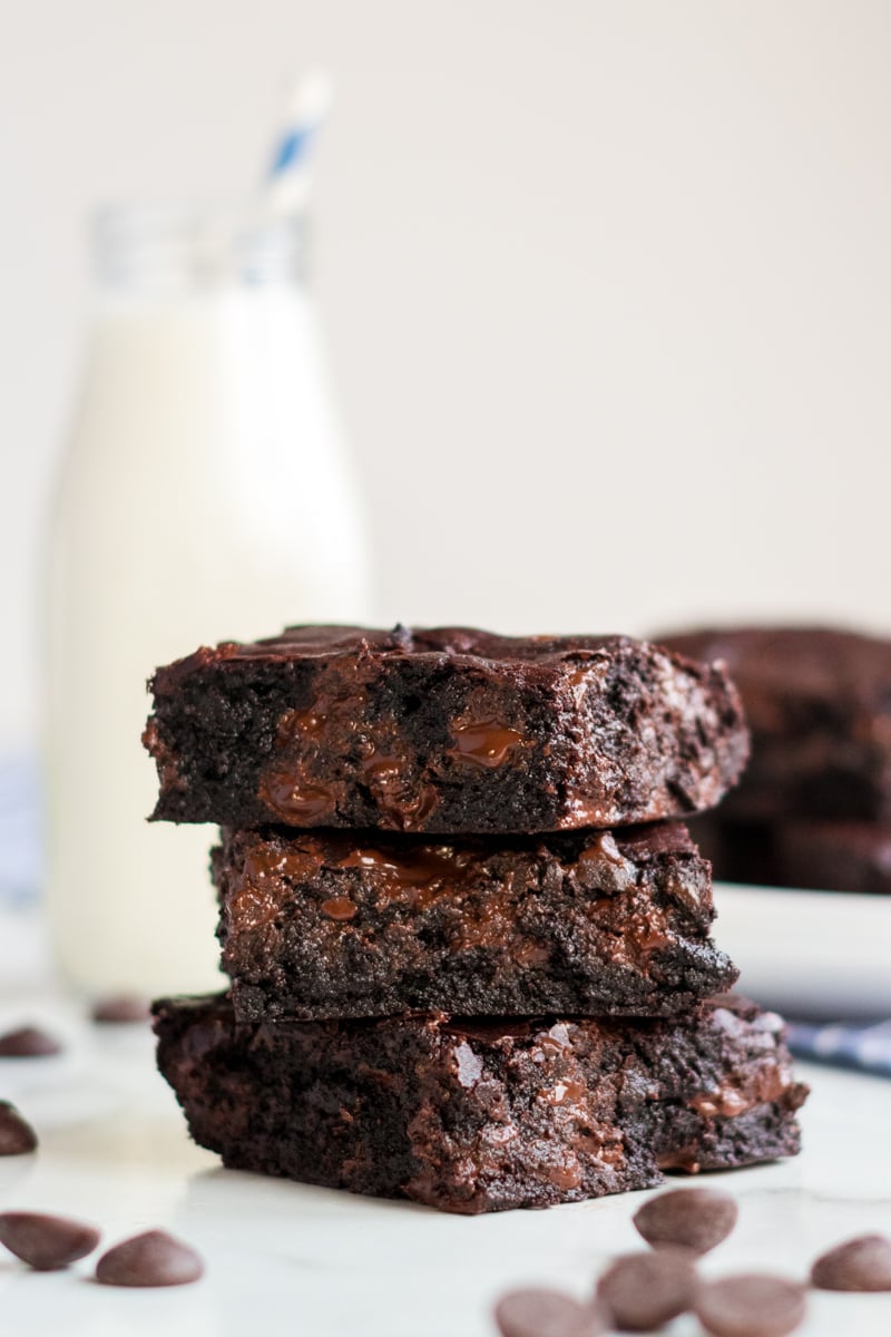 Coconut Oil Dark Chocolate Brownies are made with coconut oil instead of butter. Only 6 simple ingredients in these "from scratch" brownies - give them a shot! | www.persnicketyplates.com stack of 3 coconut oil brownies with milk in background