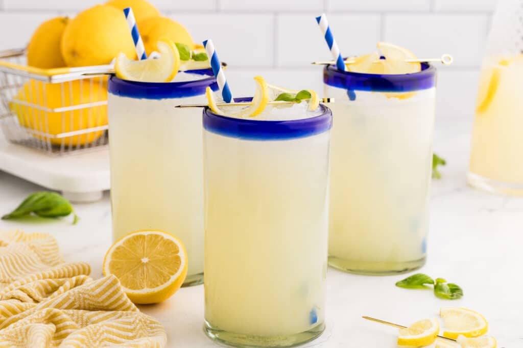 three glasses of boozy lemonade with straws.