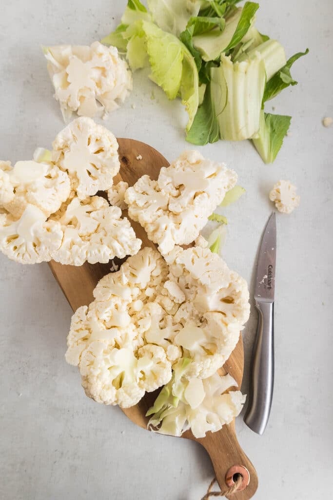 head of cauliflower on a cutting board.