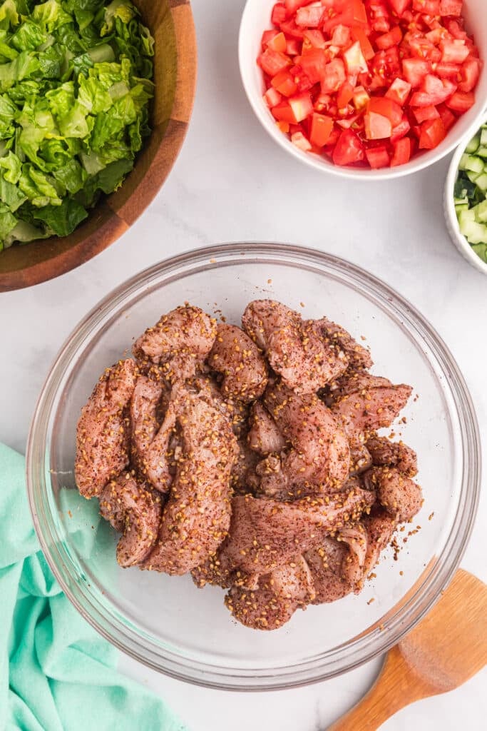 raw chicken marinating in a bowl.