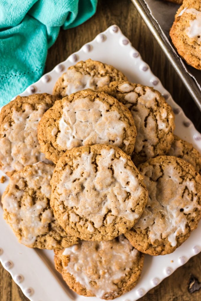 white plate stacked high with iced oatmeal cookies