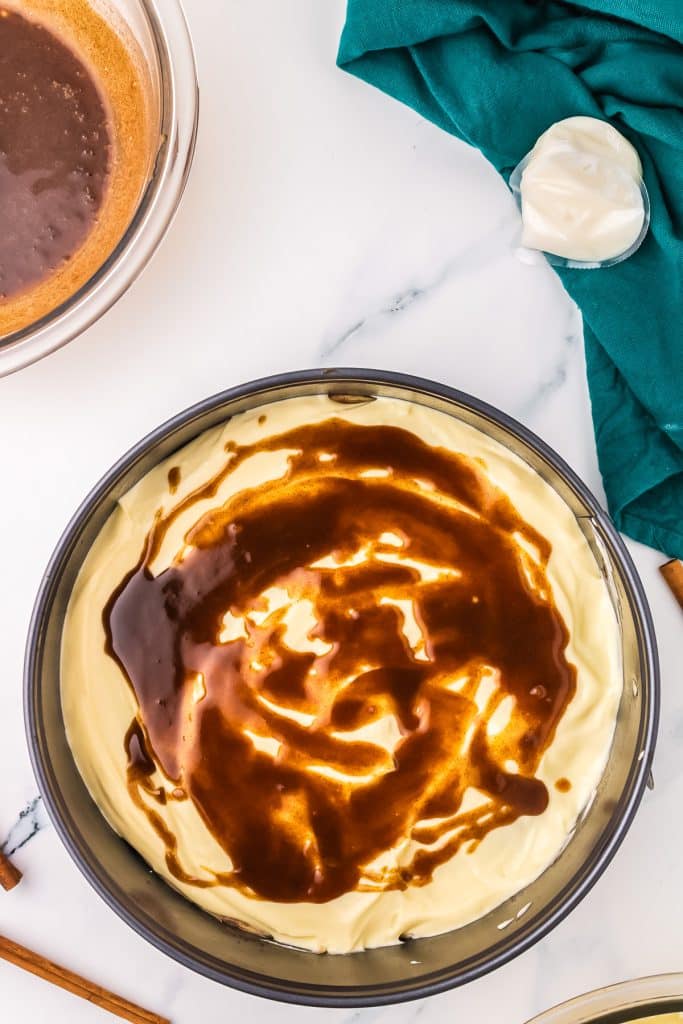 overhead shot of cinnamon filling poured on cheesecake batter.