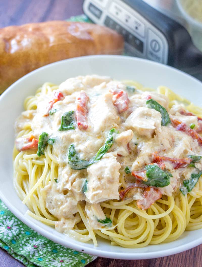 Five ingredient, super simple, Crock Pot Chicken Alfredo takes no time at all to throw together in the slow cooker. This easy crockpot chicken alfredo recipe will become a staple in your meal plan. | www.persnicketyplates.com #crockpot #slowcooker #chickendinner #chickenalfredo #easyrecipe white bowl filled with crock pot chicken alfredo