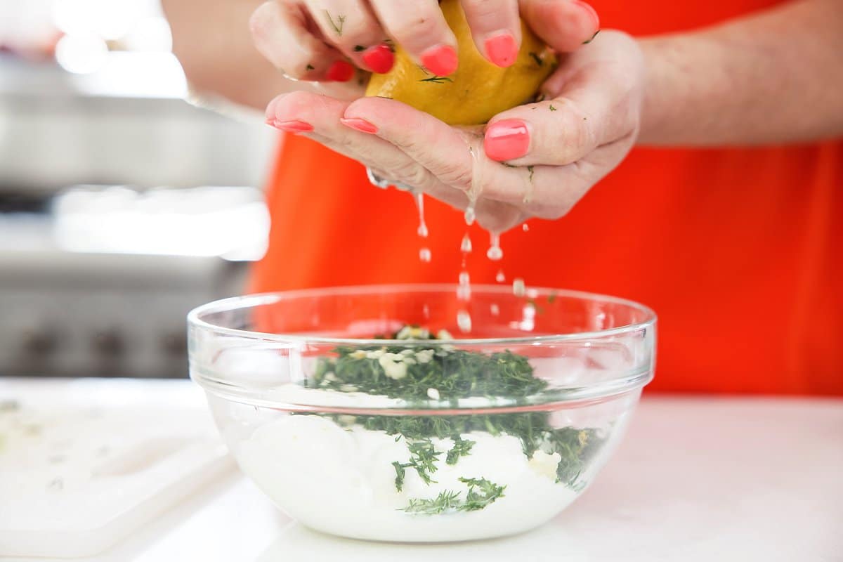 squeezing lemon into dill dressing