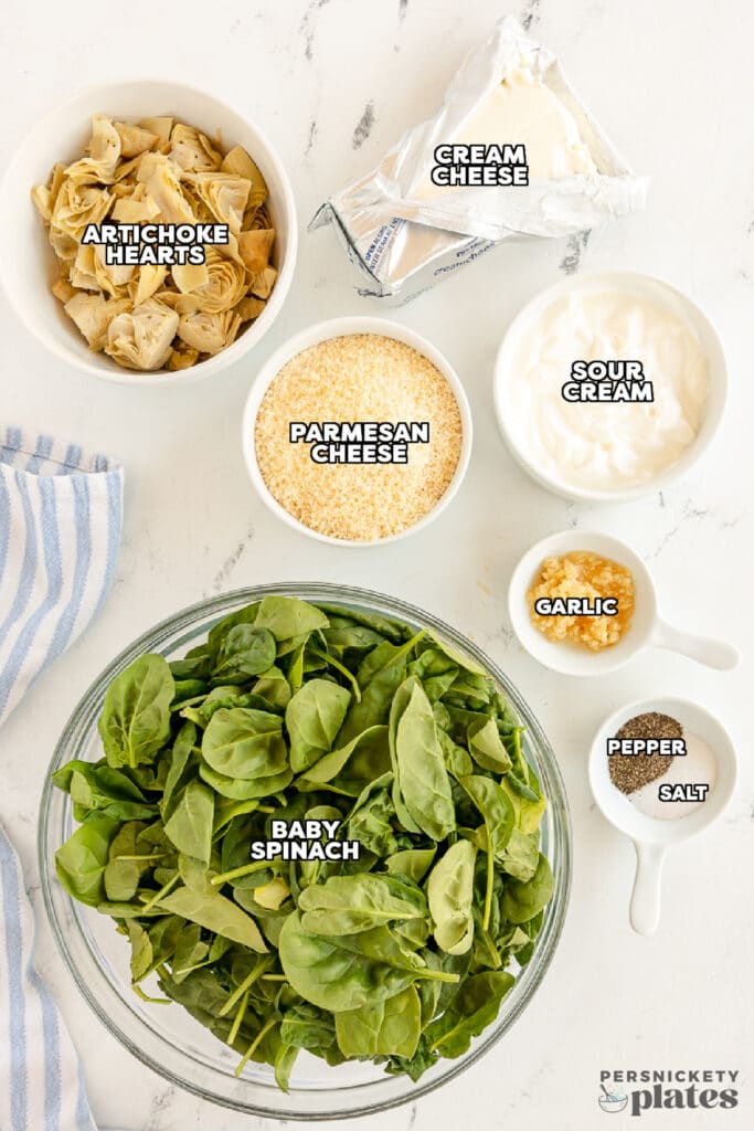 overhead shot of labeled ingredients laid out to make crockpot spinach artichoke dip.